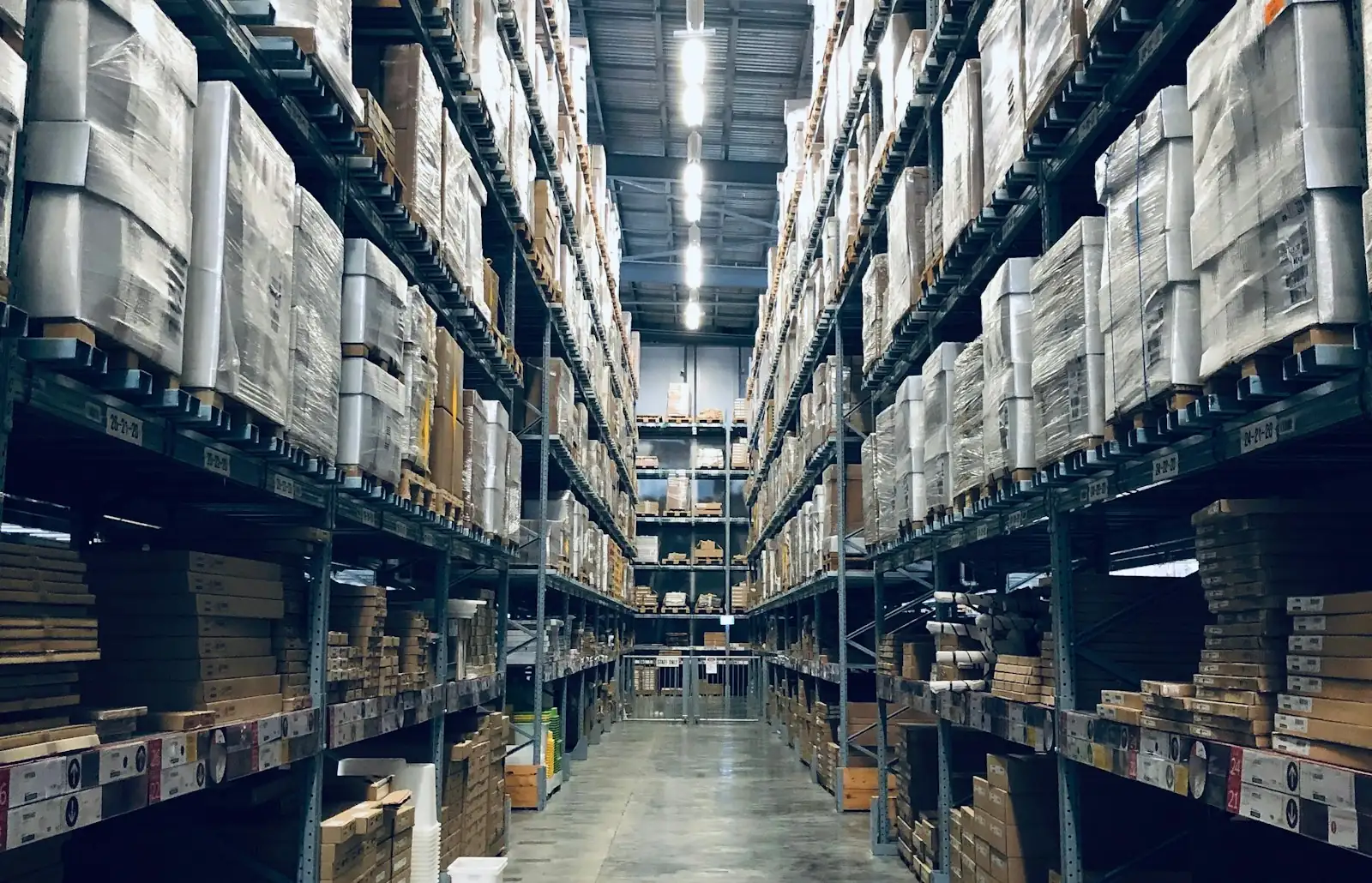 Interior de galpón con operario y mercadería en pallets